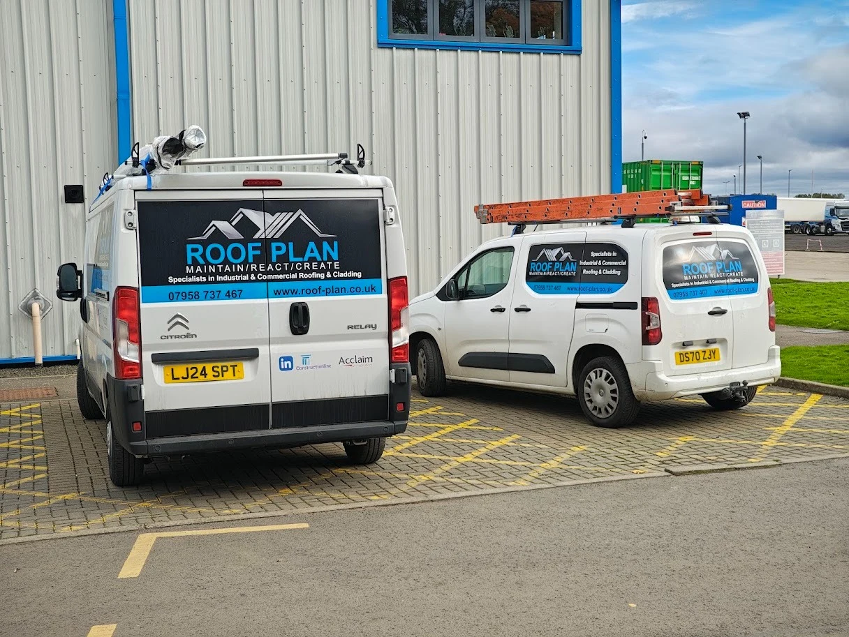 Two Roof Plan vans parked side by side at a commercial site